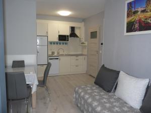 a living room with a couch and a kitchen at Apartament w centrum Ciechocinka in Ciechocinek