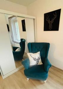 イェレニャ・グラにあるApartament Oliwiaの青い椅子(鏡の前に枕付)