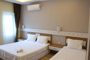 een hotelkamer met 2 bedden en een raam bij Terko hotel pansiyon in Beldibi