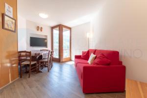 sala de estar con sofá rojo y comedor en Monte Cervino apartment AS1, en Breuil-Cervinia