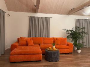 an orange couch sitting in a living room at Mandarinas in Anykščiai