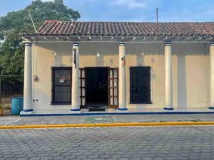 un bâtiment avec des colonnes et une porte dans une rue dans l'établissement Hotel Casa Blanca by Rotamundos, à Tlacotalpan