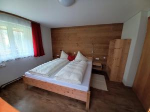 a bedroom with a bed with a wooden wall at Ferienhaus Schwendehof in Fontanella +33 photos