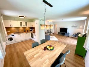 cocina y sala de estar con mesa de madera en una habitación en Sweet Home Apartment Ammersee - eco-friendly, Boxspring, Garden, WiFi, en Inning am Ammersee