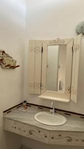 a bathroom with a sink and a mirror at Pousada Cores da Passarela - Sob nova direção in Porto Seguro +35 photos