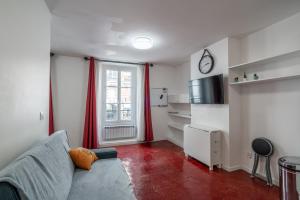 een woonkamer met een bank en een raam bij Logement entier à Paris in Parijs