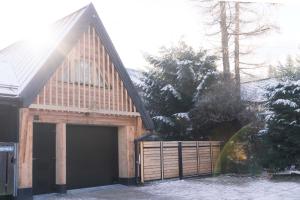 a barn with a garage door and a fence at Mount Apart Sport House in Zakopane