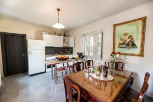 StoneVillaMouzaki Luxury Mansion في موزاكيون: مطبخ مع طاولة وكراسي وثلاجة بيضاء