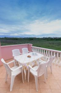 - Balcón con mesa blanca y sillas en Apartment Mara en Privlaka