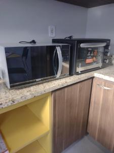 a microwave oven sitting on top of a counter at POUSADA IDEAL in Uruguaiana