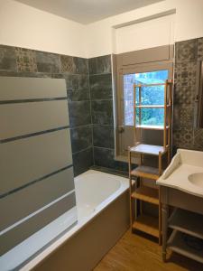 a bathroom with a bath tub and a sink at LE BIEn Zen in Lebiez +37 photos