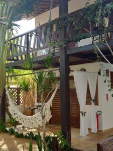 a hammock in the middle of a room with plants at Pousada Aky Jeri in Jericoacoara