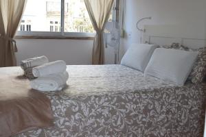 1 dormitorio con 1 cama con toallas en Chez Jacqueline en Lisboa