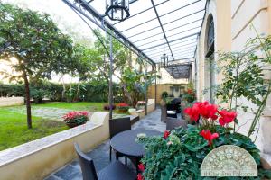 a patio with tables and chairs and red flowers at Il Giardino Falcone in Catania