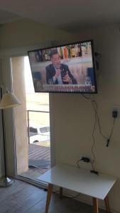 TV de pantalla plana colgada en una pared sobre un banco en La Bertiana en 