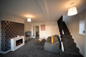 ein Wohnzimmer mit Couch und Kamin in der Unterkunft A beautiful 3-bed Family House in Ormskirk, sleeps 5 in Ormskirk