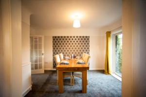 ein Esszimmer mit einem Holztisch und Stühlen in der Unterkunft A beautiful 3-bed Family House in Ormskirk, sleeps 5 in Ormskirk