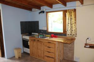 a kitchen with a sink and a stove and a window at Choique in San Carlos de Bariloche