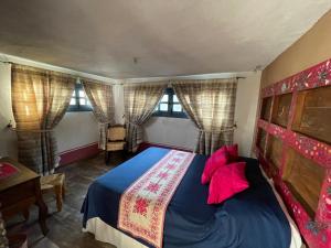 1 dormitorio con 1 cama en una habitación con ventanas en La Casona Azul Boutique Hotel, en Malinalco