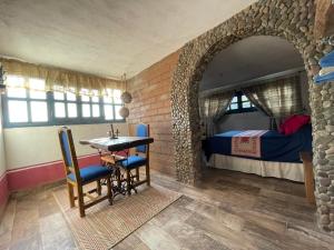 ein Zimmer mit Tisch, Stühlen und einem Bett in der Unterkunft La Casona Azul Boutique Hotel in Malinalco