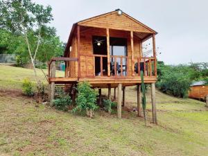 Casa de madera con porche en un campo en Entendeni Lodge SelfCatering, en Inanda