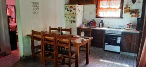 a kitchen with a wooden table and chairs in it at Casa con piscina en Sierra de los Padres in Mar del Plata