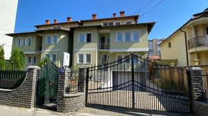 a house with a black fence and a gate at Bus Station Hostel in Pristina