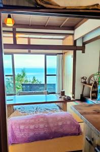 a bedroom with a bed and a large window at AKUA inn in Awaji