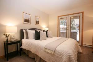 sypialnia z dużym łóżkiem i oknem w obiekcie CRYSTAL FOREST 2BR Ski In Ski Out with PRIVATE Hot Tub w mieście Sun Peaks