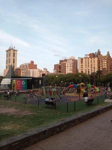 a park with a playground with people in a city at Excepcional dpto frente a Plaza de la Intendencia in Córdoba