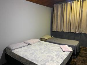 2 camas en una habitación con ventana en Regi House Hostel, en Vitória