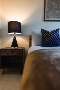 een slaapkamer met een bed en een lamp op een nachtkastje bij The Skyline Suite - *Private Balcony* *Views* in Glasgow