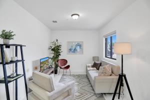 sala de estar blanca con sofá y sillas en Renzzi Wynwood Apartments en Miami