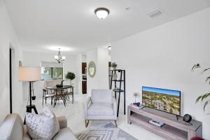 a living room with a tv and a couch and a table at Renzzi Wynwood Apartments in Miami +31 photos