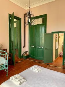 Una habitación con puertas verdes y una cama con toallas en Casa Bellavista en Villa Lía
