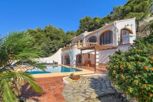 a villa with a swimming pool and a house at Casa Patricia in Jávea