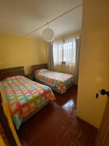 een kleine kamer met 2 bedden en een raam bij Casa grande Campestre, Vicuña, Valle del Elqui in Vicuña