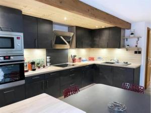 a kitchen with black cabinets and a counter top at Gîte Gérardmer, 3 pièces, 4 personnes - FR-1-589-393 in Gérardmer