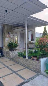 a house with a stone patio with an umbrella at Villa Swandara Rancamaya With Netflix, Youtube, SmartTV and Nice Backyard in Bogor