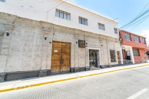 an old stone building with wooden doors on a street at Hostal La Posada Del Sol in Arequipa
