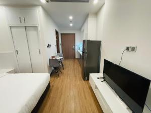 une chambre avec un lit et une télévision à écran plat dans l'établissement Gavi Home - Luxury Apartment Vinhome Green Bay Mễ Trì Hà Nội, à Hanoï