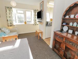 een woonkamer met een televisie en een kamer met een bank bij Bryn Melyn Artist's Cottage in Llanelltyd