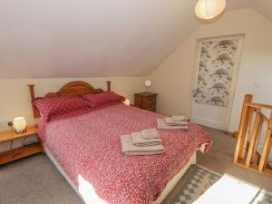 a bedroom with a large bed with towels on it at Bryn Melyn Artist's Cottage in Llanelltyd