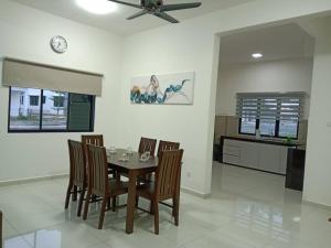 Kampong Sungai Udang的住宿－Pangkor Happy Villa @ 88 Resort Villa Riadah，一间带桌椅的用餐室和一间厨房
