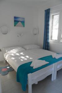 a white bed in a bedroom with a window at Apartment Tara in Nečujam