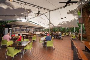a restaurant with people sitting at tables and chairs at Cape Trib Beach House in Cape Tribulation