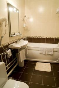 a bathroom with a tub and a sink and a toilet at Ilmar City Hotel in Kazan