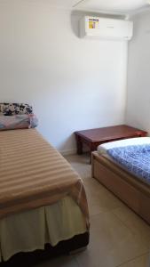 sypialnia z 2 łóżkami i stołem w obiekcie DIANELLA Budget Rooms Happy Place to Stay & House Share For Long Term Tenants w mieście Perth
