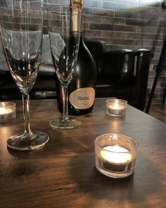 een tafel met twee glazen en een fles wijn bij La suite Grenoble spa jacuzzi et sauna privatif in Grenoble