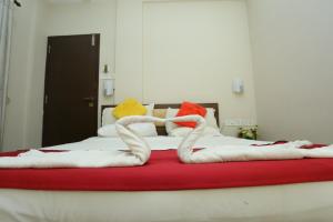 uma cama com dois cisnes feitos de toalhas em Hotel Innate Inn em Alwaye